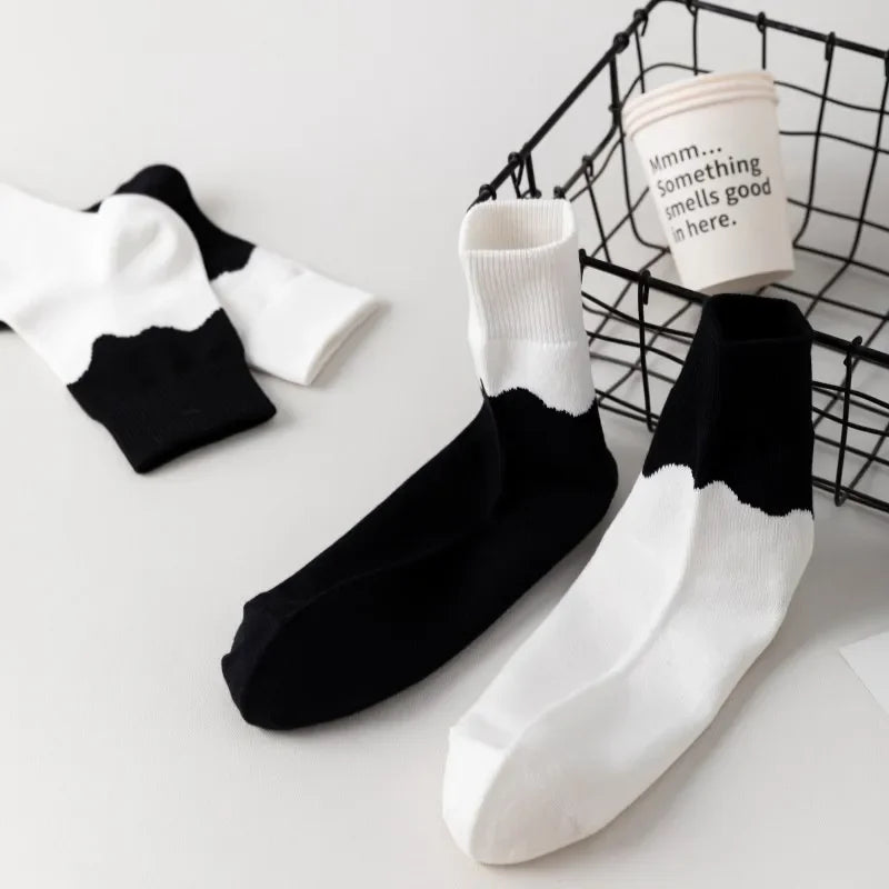 Black and white socks with a coffee cup in the background
