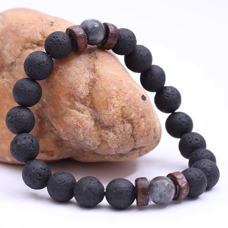 Black beaded bracelet with brown and gray accents on a rock background