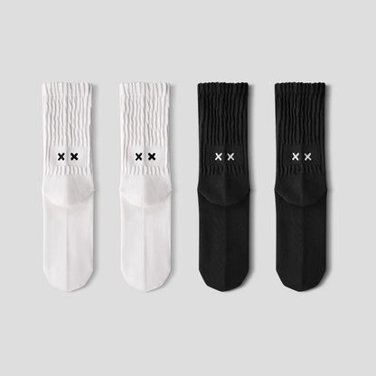Two pairs of white socks and two pairs of black socks with logo on a light gray background