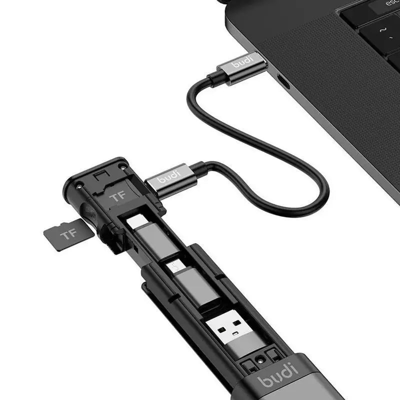 Multi-device charging cable with USB ports and TF card slot attached to a laptop.