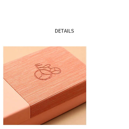 Close-up of a peach-colored box with a logo on a beige background