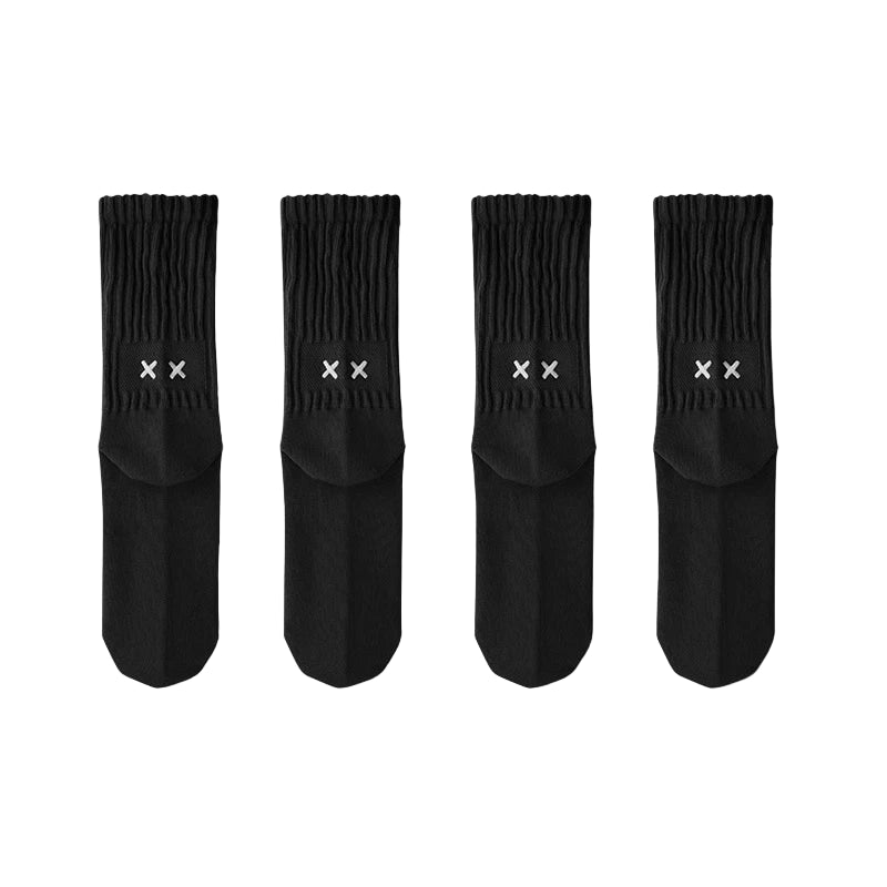 Four black socks with white logo on a light gray background