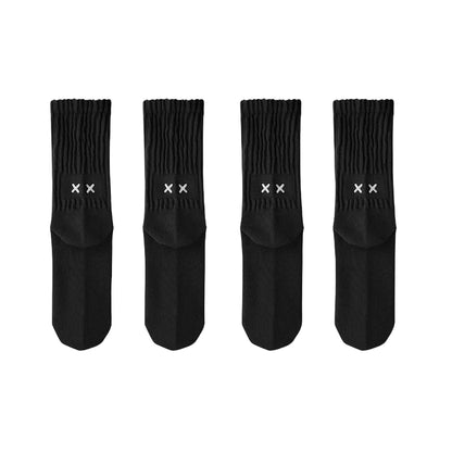 Four black socks with white logo on a light gray background